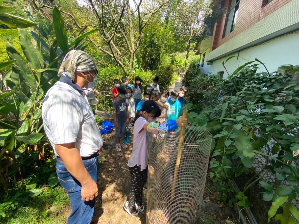 吳加雄博士指導學生攪拌堆肥網中的落葉加速腐化