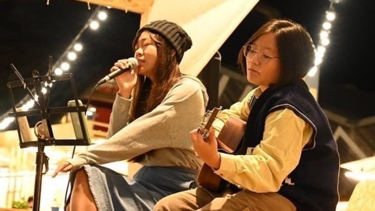 在鐵花村微光市集駐唱的葦涵Nicole(左)和吉他手均君Jenny(右)