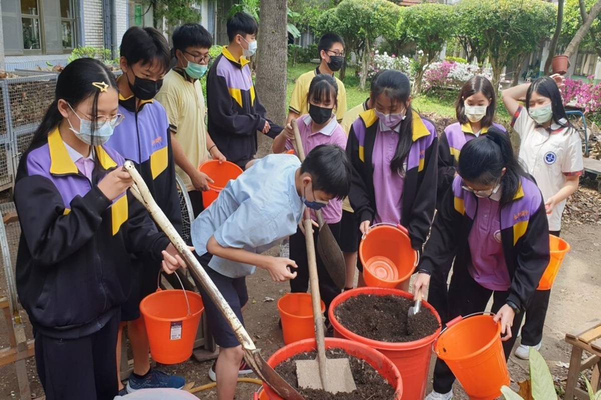 永和國中的師生在落葉堆肥場鏟土 (新北市教育局提供)