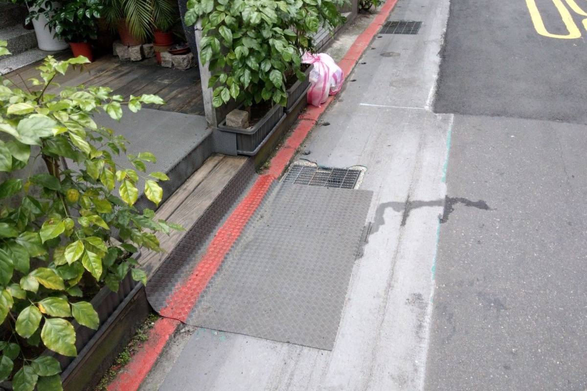 水溝蓋上常見腳踏墊等障礙物會讓雨水排不進水溝，造成路面積淹水現象