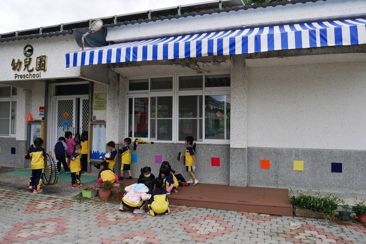 臺東縣瑞豐國小附幼增設幼兒園大門前走道兩側塑木地板，為進入教室前的多功能轉換空