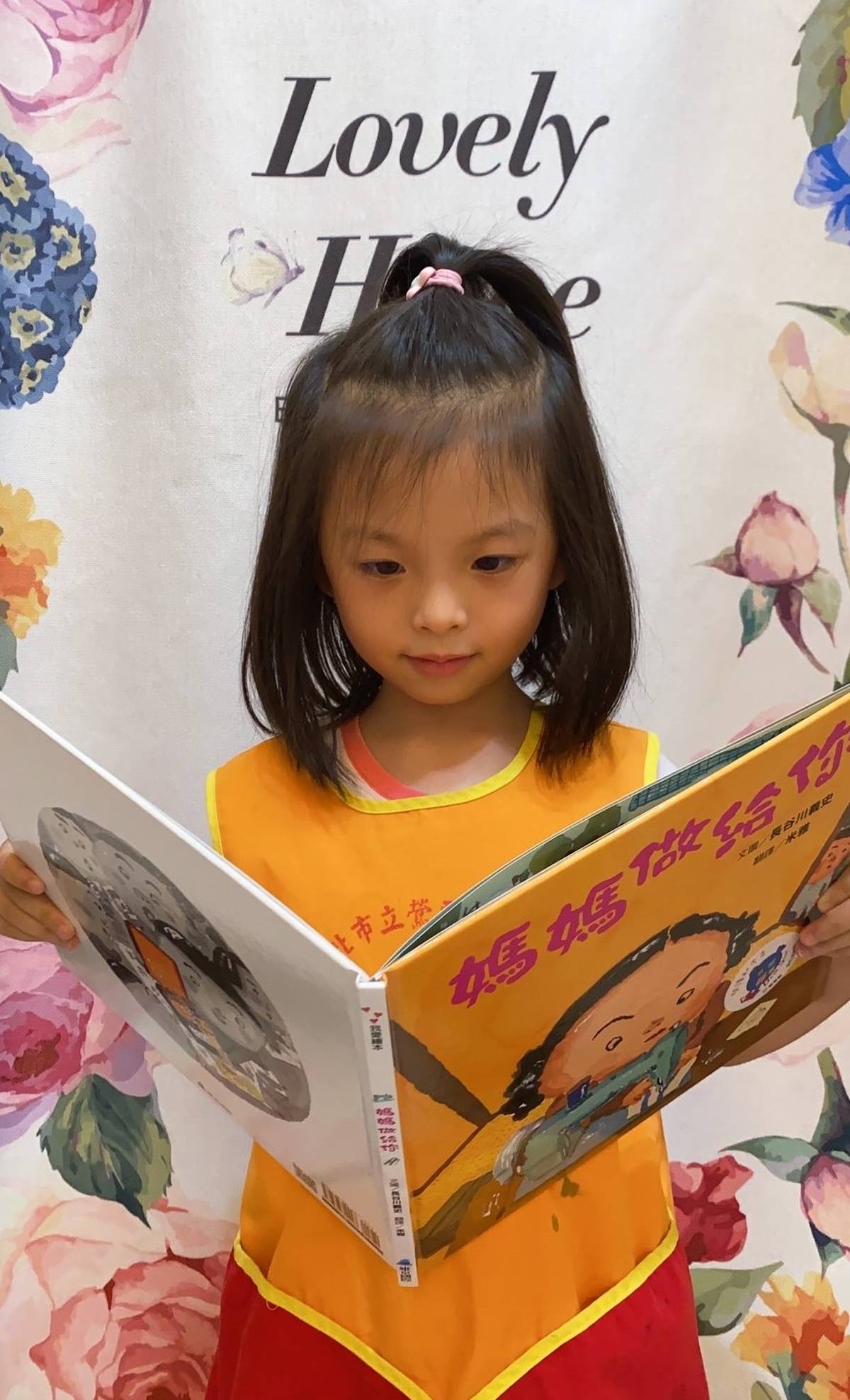 沛沛(化名)在家穿圍兜練習講《媽媽做給你》故事