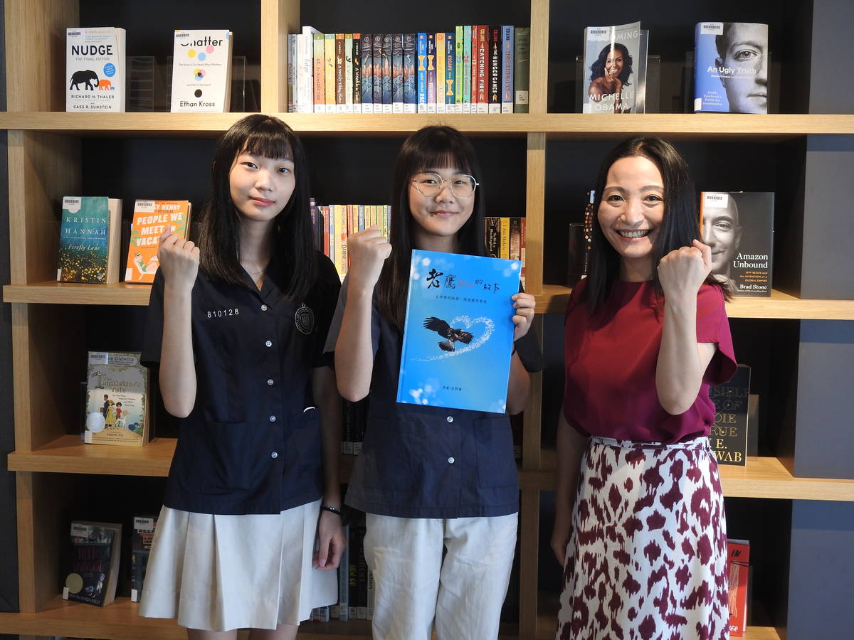 沈利倩(中)與好朋友陳妍安(左)以及華盛頓中學校長劉一欣(右)在圖書館展示自己創作的老鷹紅豆兒童繪本