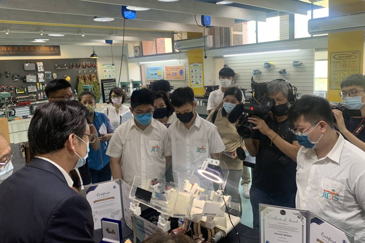 副市長劉和然(左)聆聽學生介紹在科技中心完成的作品