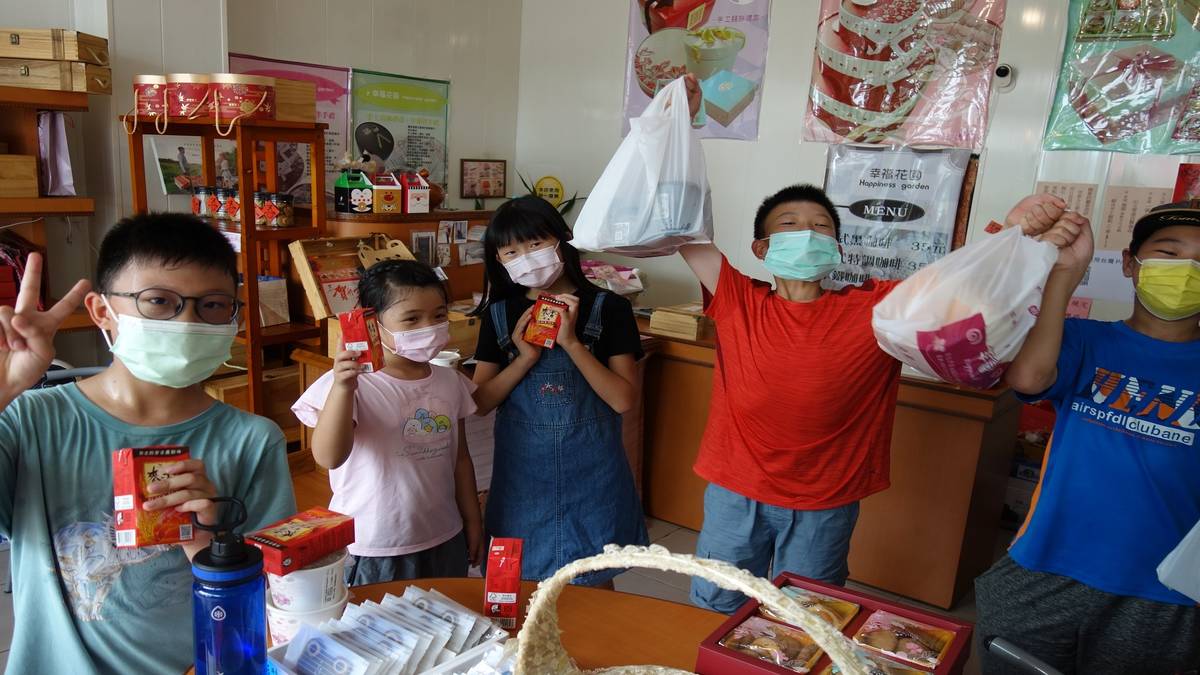 快官國小學生開心的拿起在地麵包店的麵包，期待動手做果醬吐司