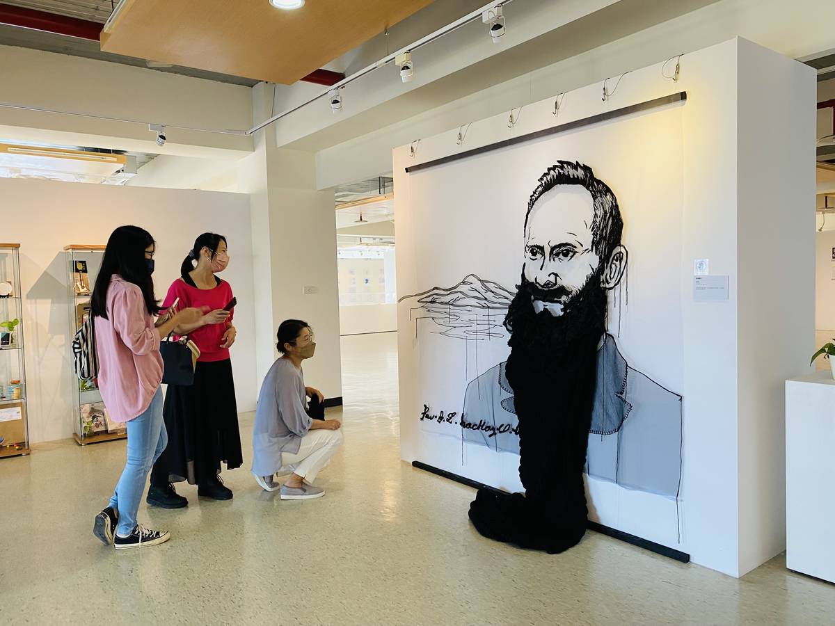 淡古駐村藝術家簡俊成（左1）與參觀民眾以口罩遮臉與作品《寂靜的心》合影，留下有趣的畫面。