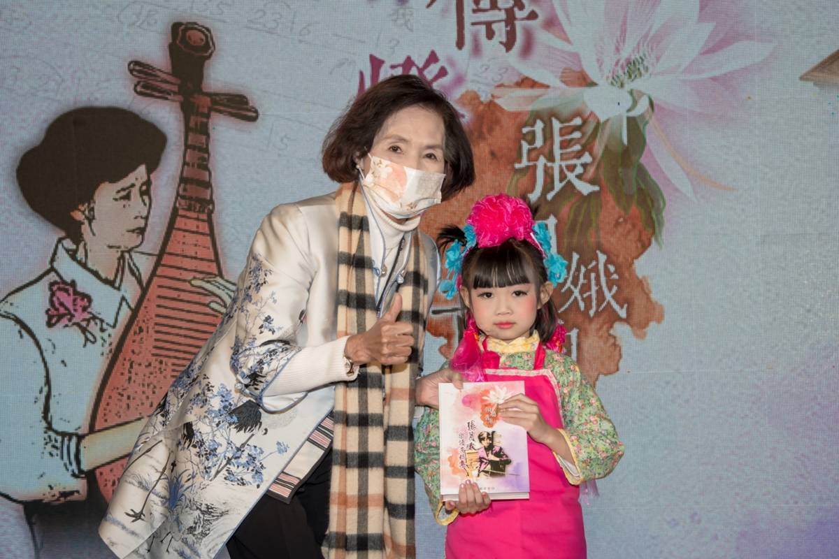 宜蘭縣長林姿妙（左）將《傾聽舊卷~張月娥樂譜遺稿集》專書給予小朋友。