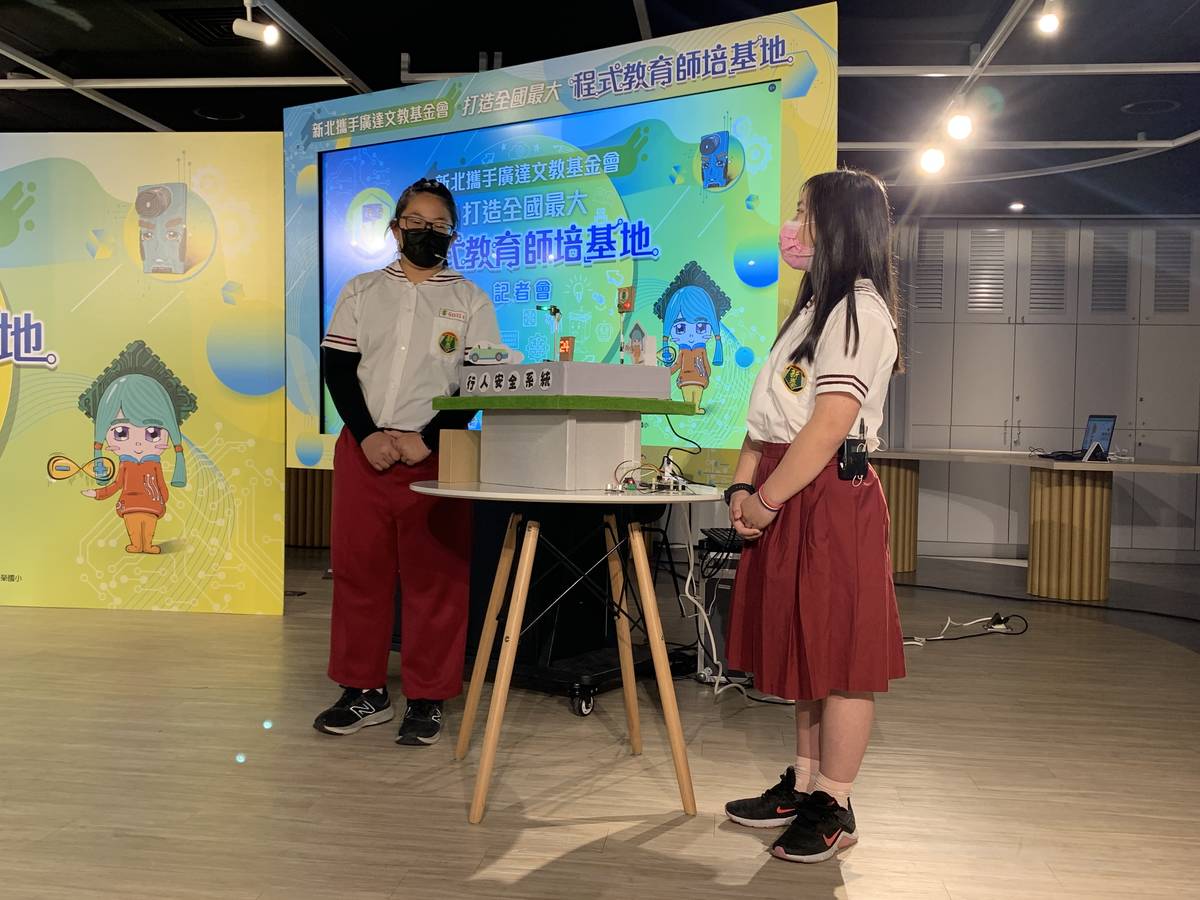 新泰國小林羿均(左)與賴亭庭(右)同學就利用廣達文教基金會提供的裝置，特別設計出行人安全系統