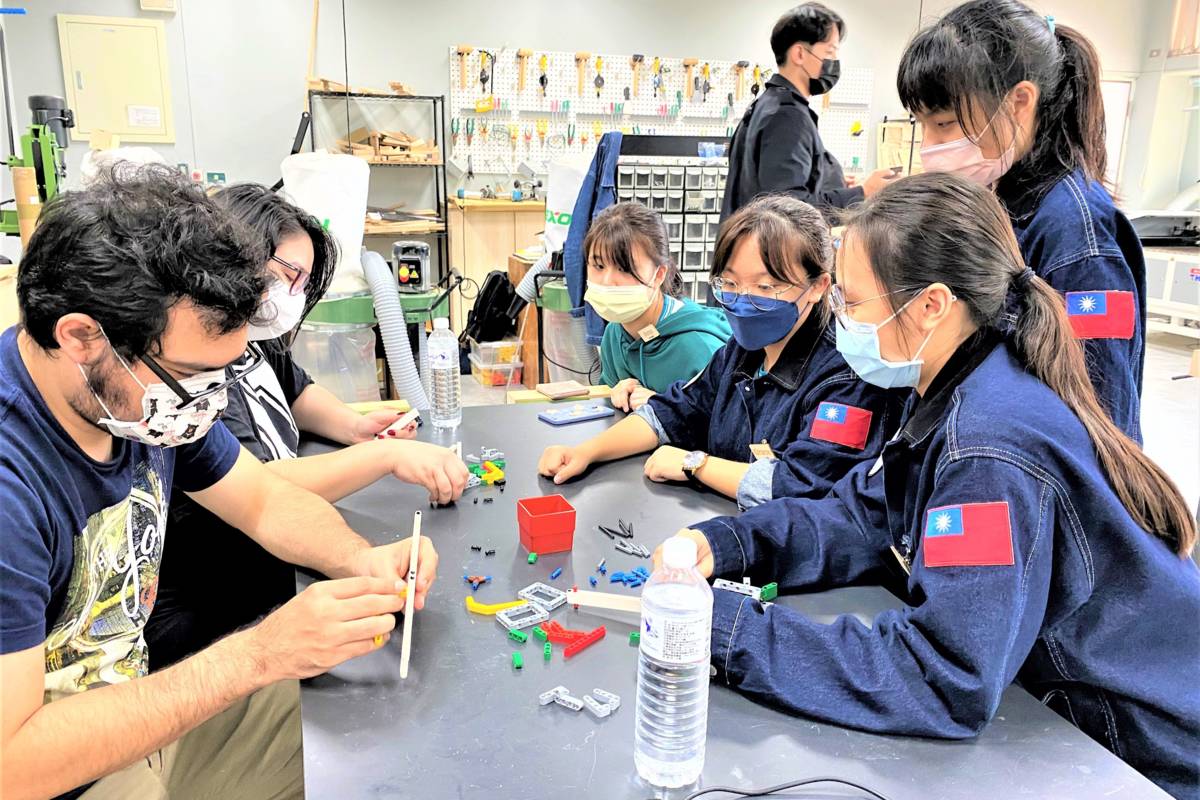石碇高中學生細心跟外籍生講解如何打造自己的一把樂高手槍