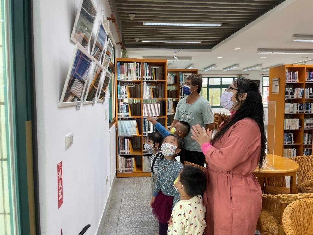 幼兒邀請家長到圖書館觀賞攝影展並熱情解說