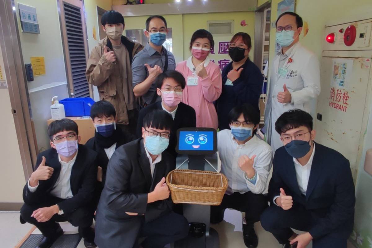 元智與桃園醫院合作，利用機器人降低傳染風險，參與人員於隔離病房前合影 (元智提供)