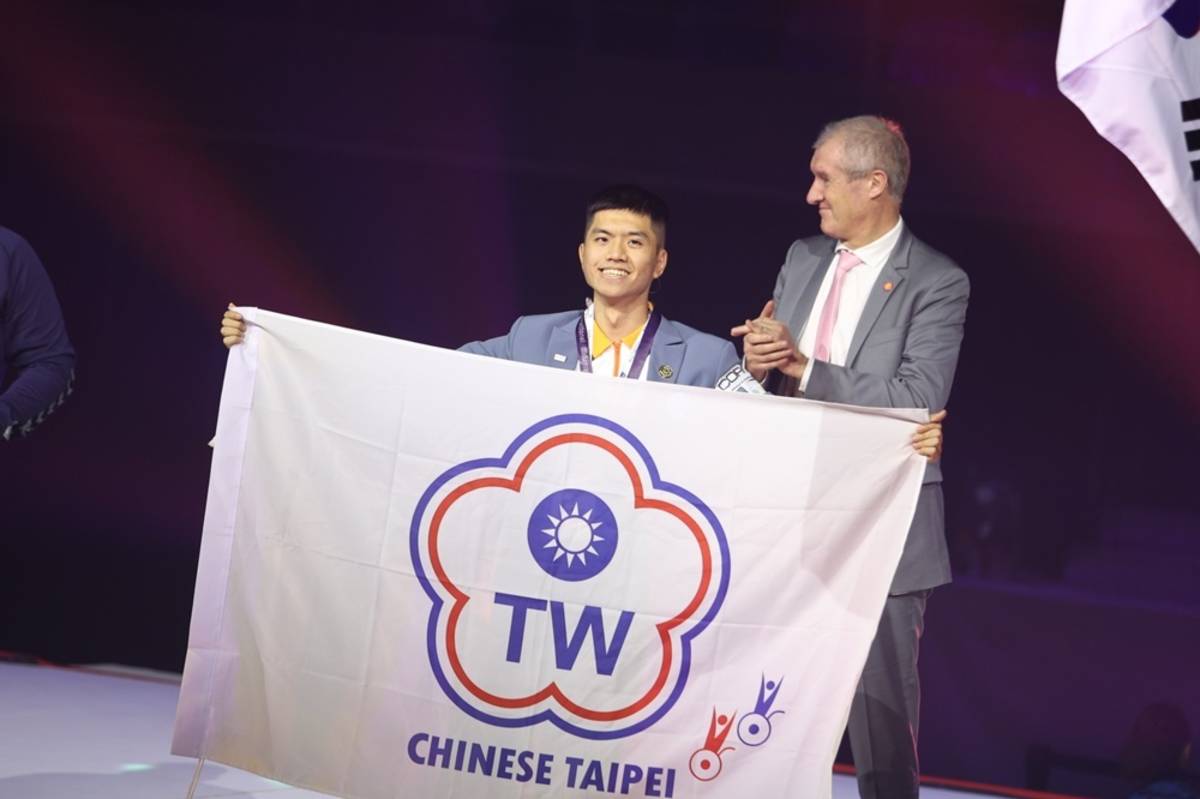張丞瑨在臺上舉出中華台北隊旗（圖源：雲科大）