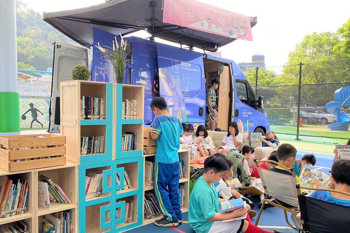 學生在臺北市立圖書館行動書車上享受閱讀