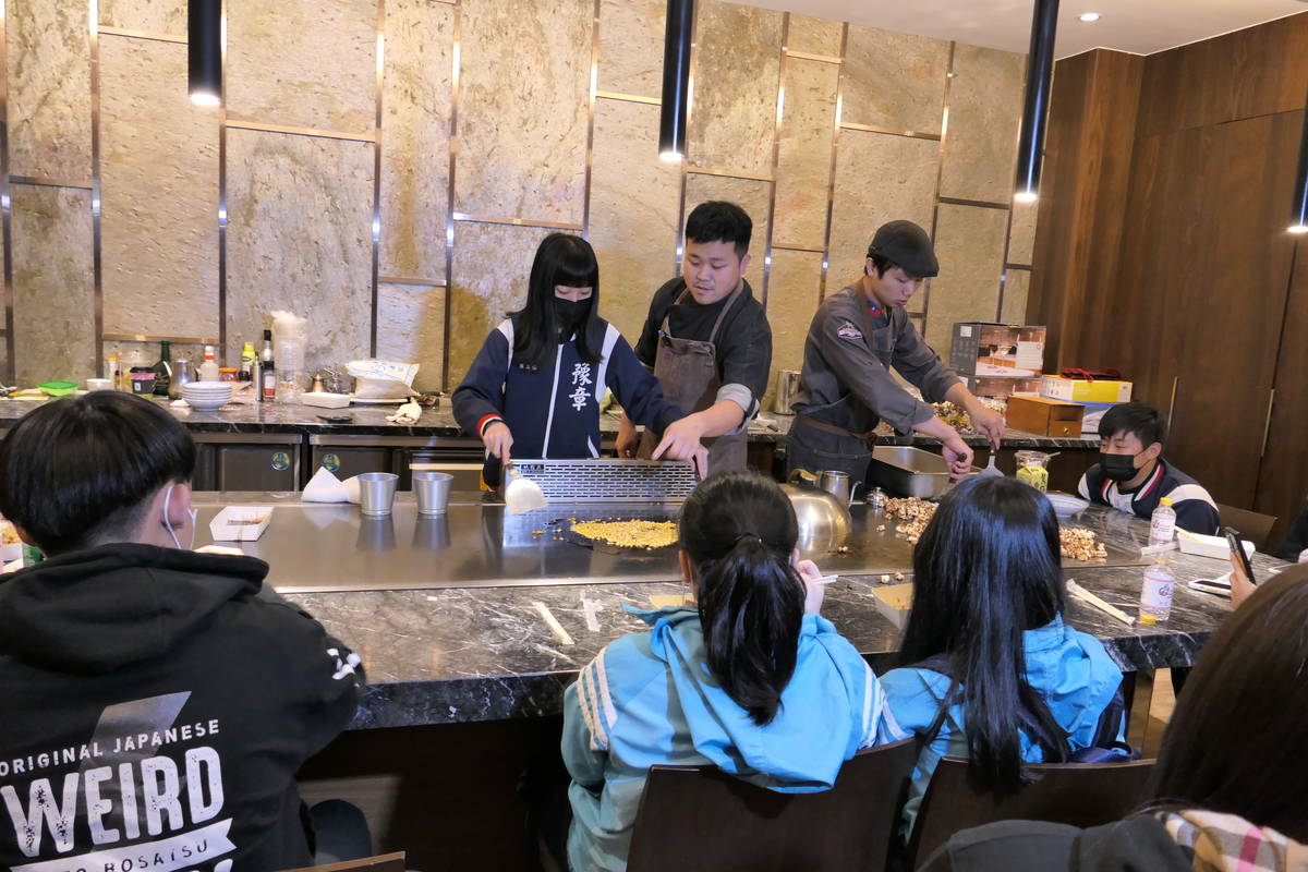 醒吾科大餐旅系朱俊松老師在鐵板燒教室帶領學生製作爆米花，學生驚呼鐵板也能爆米花 (醒吾提供)
