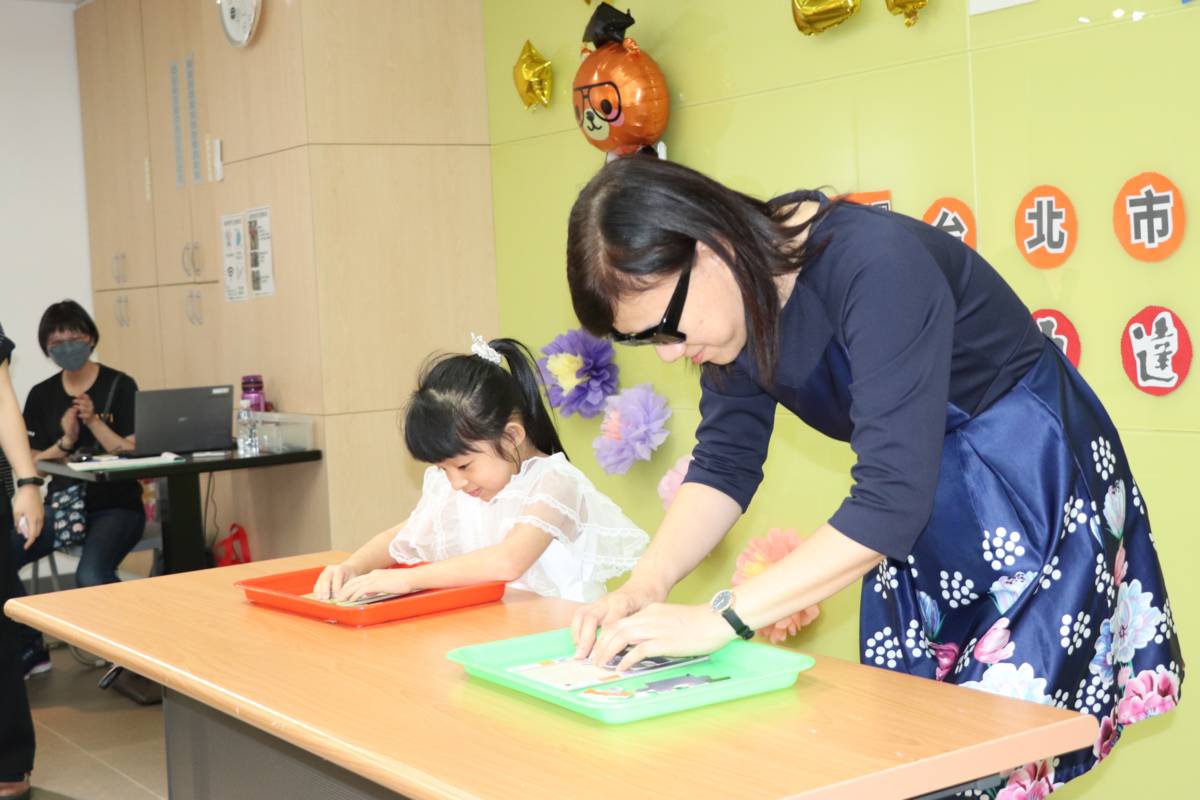 臺北市教育局特殊教育科官月蘭科長與早療畢業生一起互動