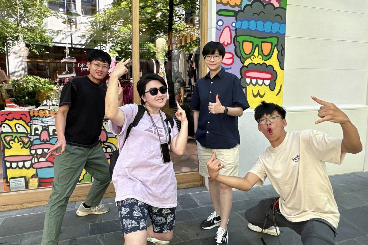 華梵美術系同學在楊侖教授（右二）導覽下，參觀藝術街區塗鴉藝術家Juay的作品。(華梵大學提供)