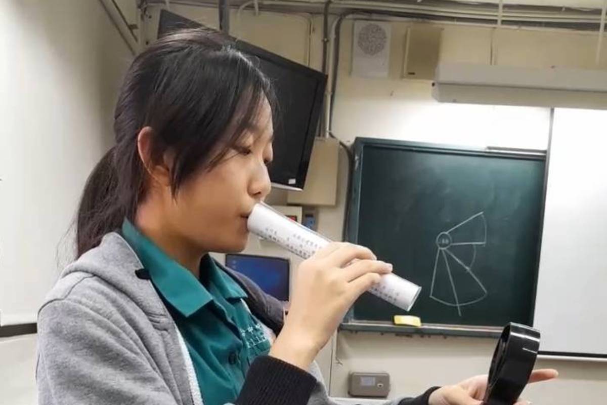 照片說明：同學本來的發想是請太空人吹直笛，但在後續的發表會上被建議改成用管子吹氣，他們便利用地科教室的風速計及隨手可得的講義捲成紙捲筒進行測試，最後成功獲選。

