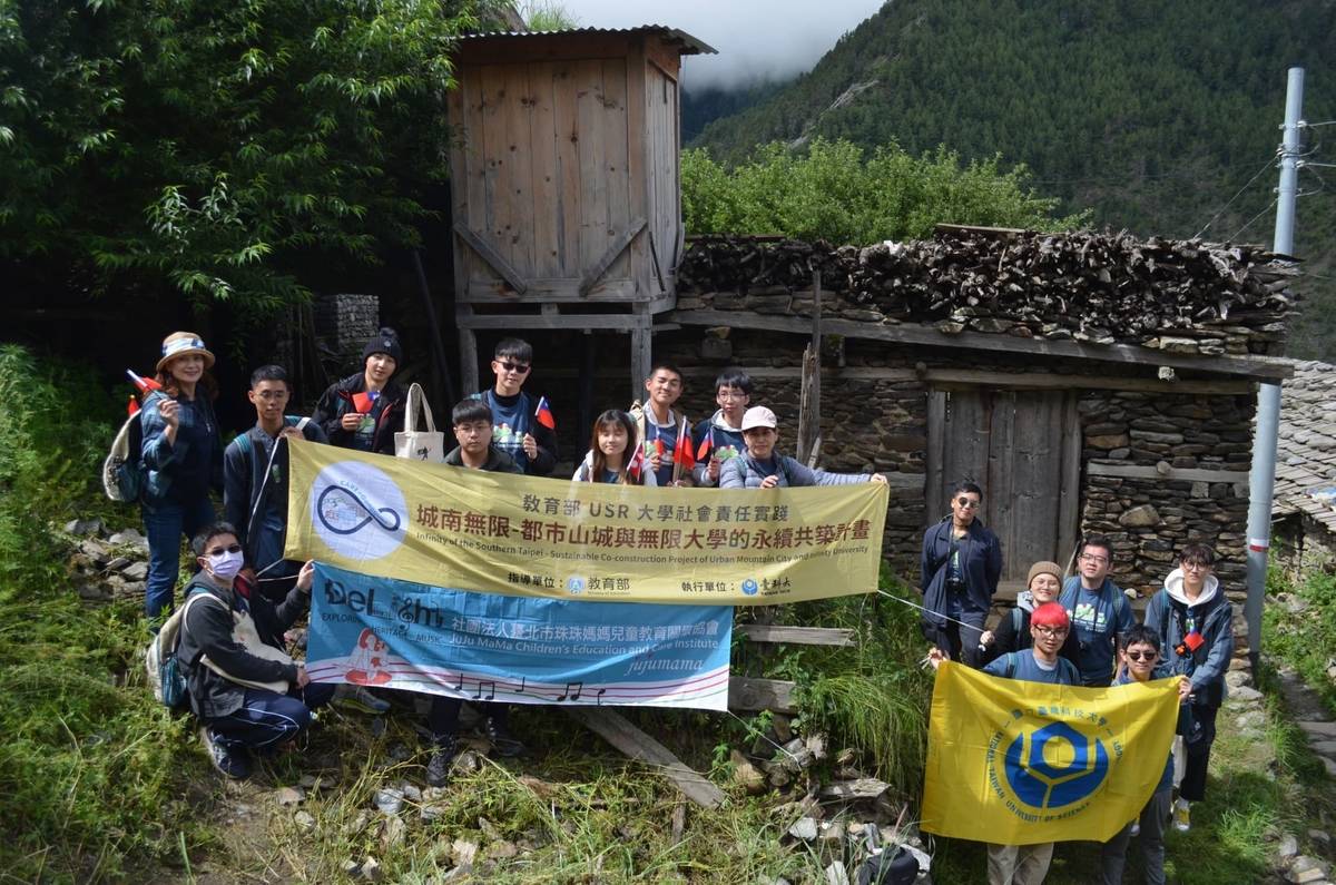臺科大團隊和臺北市珠珠媽媽兒童教育關懷協會在欲修復的百年石板屋前合影。(臺科大提供)