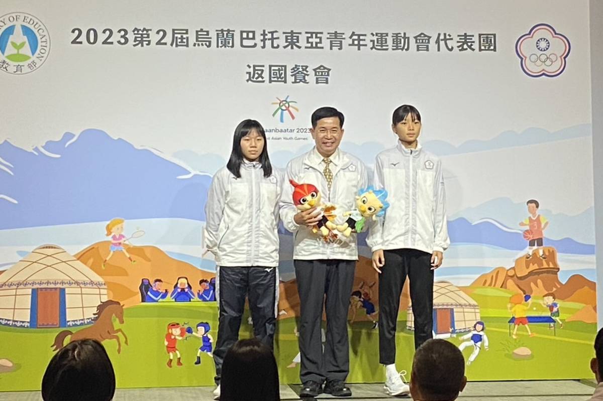 桌球選手彭郁涵（左）、跆拳道選手黃敬芸（右）將紀念品致贈給潘文忠部長。