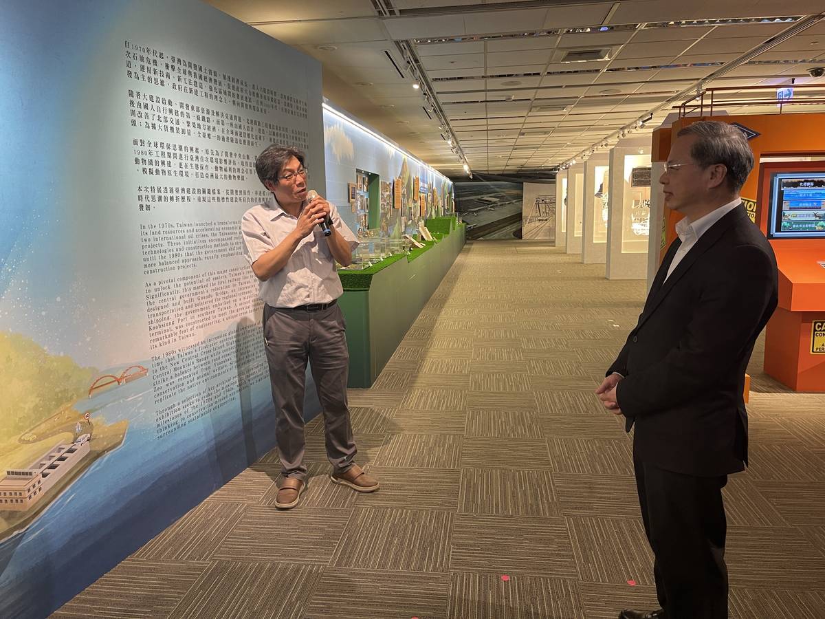 策展人陳怡行向國發會主委龔明鑫介紹展覽主題