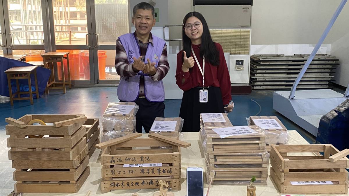 學生邱忠信(左)在112年樂齡中心成果發表會和小朋友們分享，利用國小課桌椅木頭做成的陀螺。(記者蘇瑞雯攝)