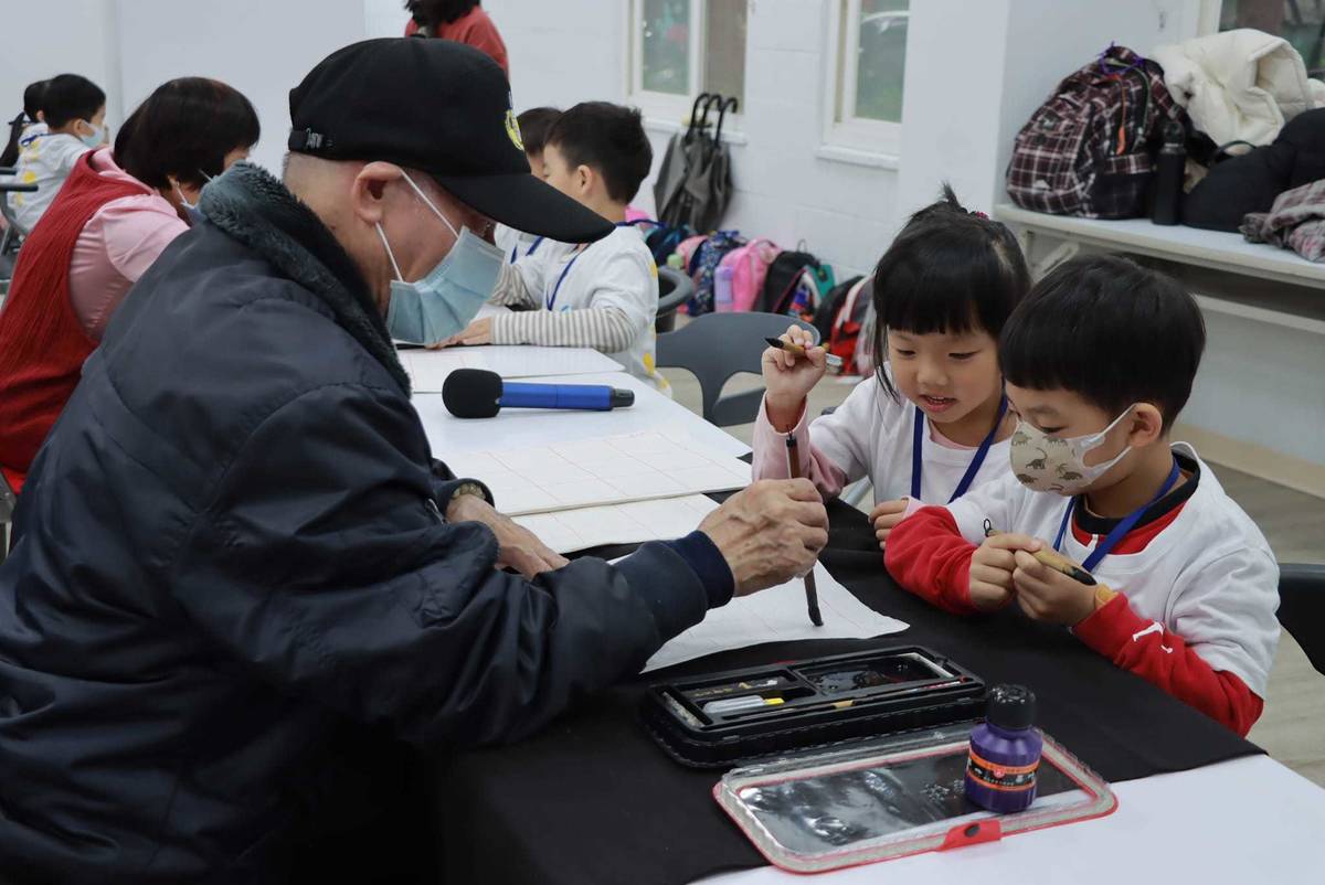 孩子們好奇專注看著爺爺奶奶一筆一畫的書寫