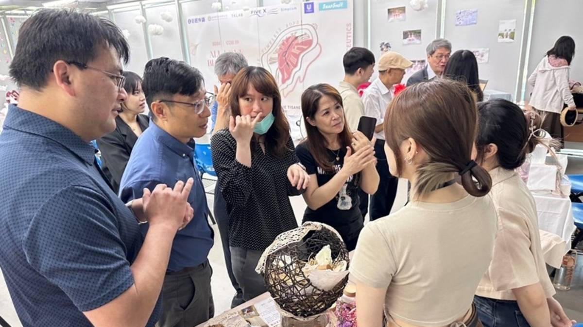 中醫大藥妝系畢展會場，師生參觀畢業展各式保養產品。