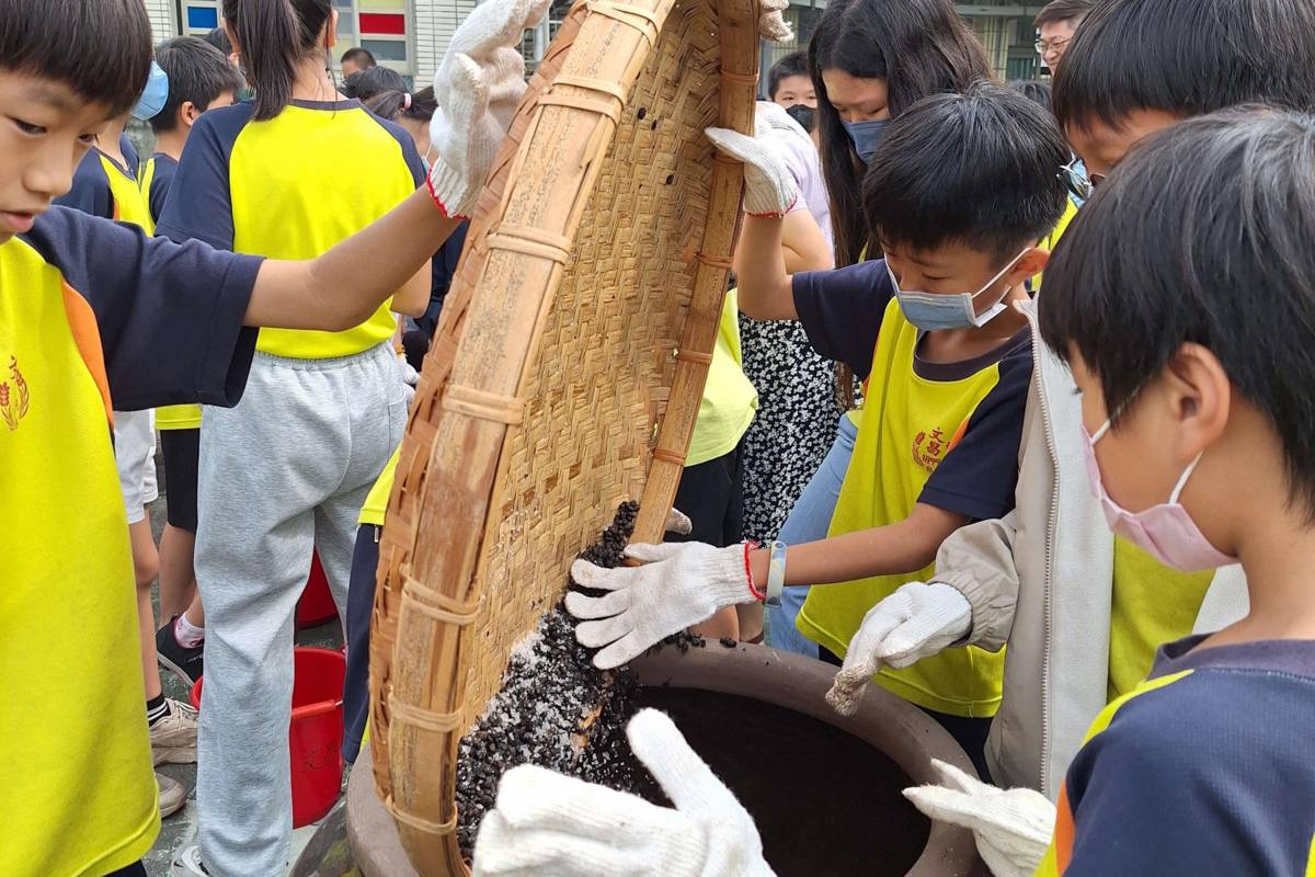 學生們將黑豆倒入醬缸（圖源：雲林縣政府）