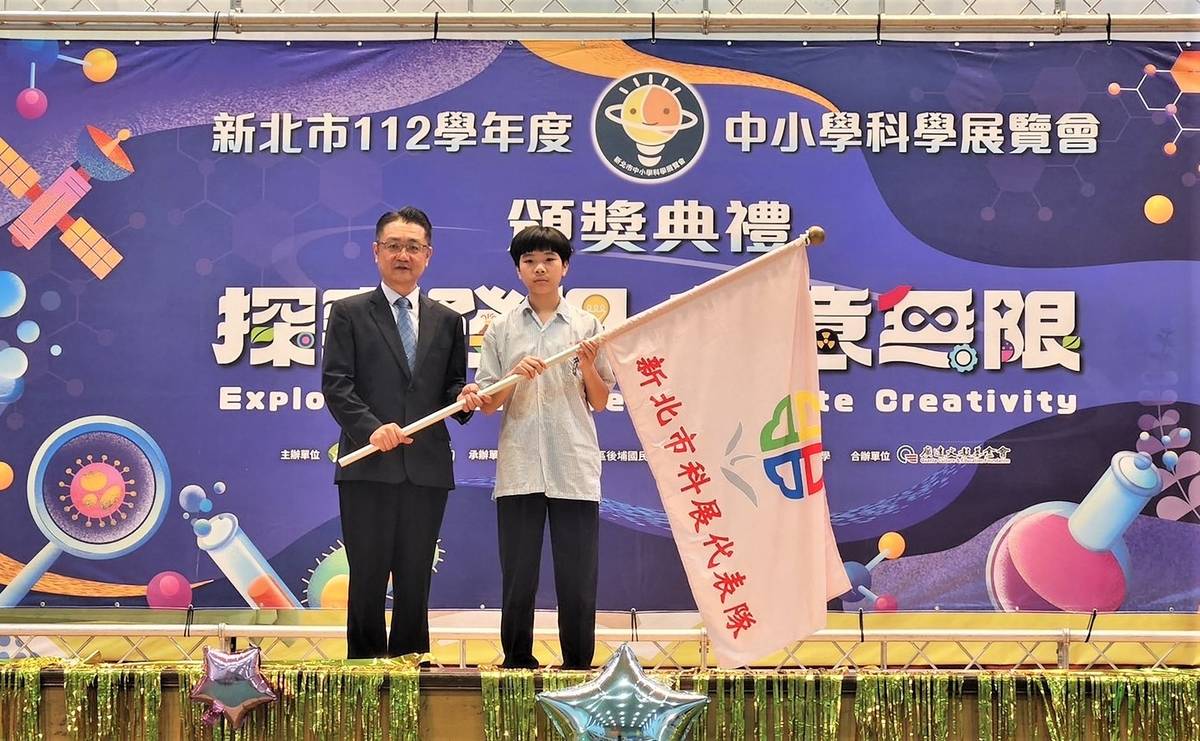 新北市科展頒獎典禮教育局劉明超副局長進行新北代表隊授旗，由文山國中李昀諺同學代表