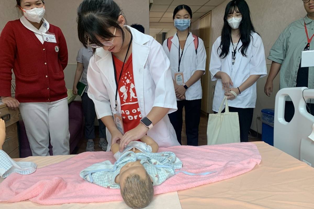 學童親手幫新生兒模型穿衣服換尿布