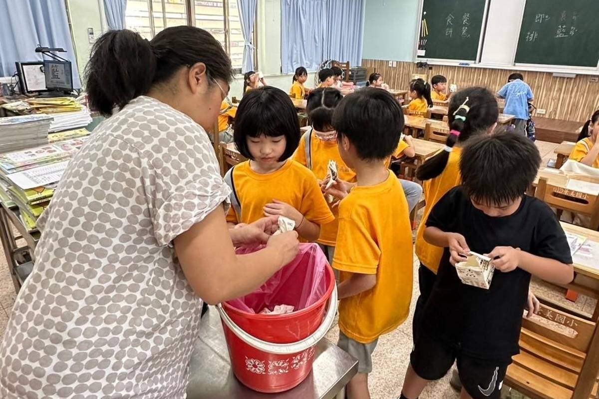 景美國小低年級導師教導學生如何回收牛奶紙盒
