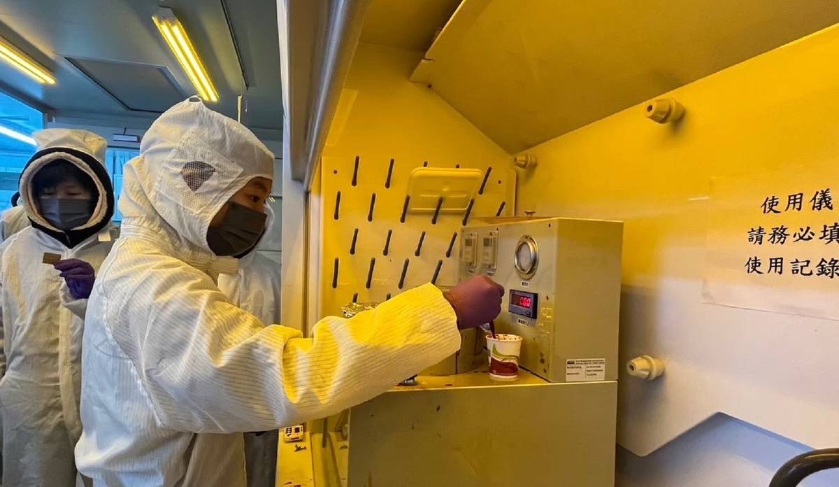 樟樹實中半導體課程學生在黃光無塵室內操作旋轉塗佈機，進行光阻塗佈步驟