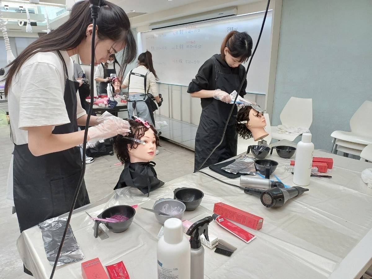 能仁家商美容科王麗萍同學(左)專注練習美容科專業技能