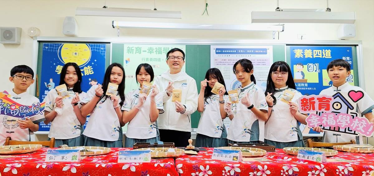 教育局長與學生一起秀出幸福香草茶包，展現新育幸福學校的成果
