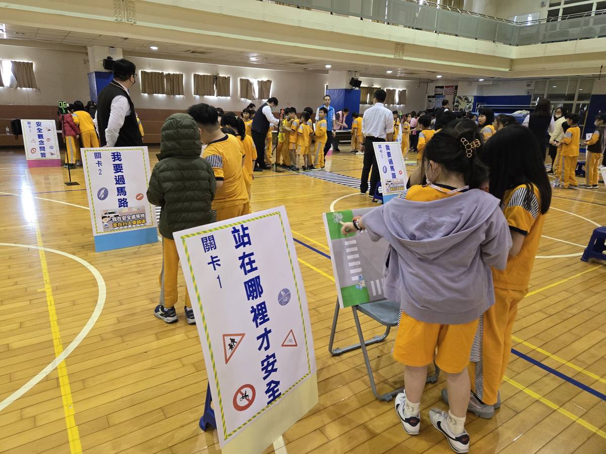 學生認真討論等候過馬路應該站在哪裡才安全