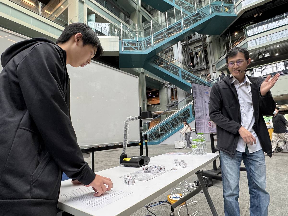 中原大學溫文鈺教授於兒童節教民眾玩量子井字棋。(科教館提供)