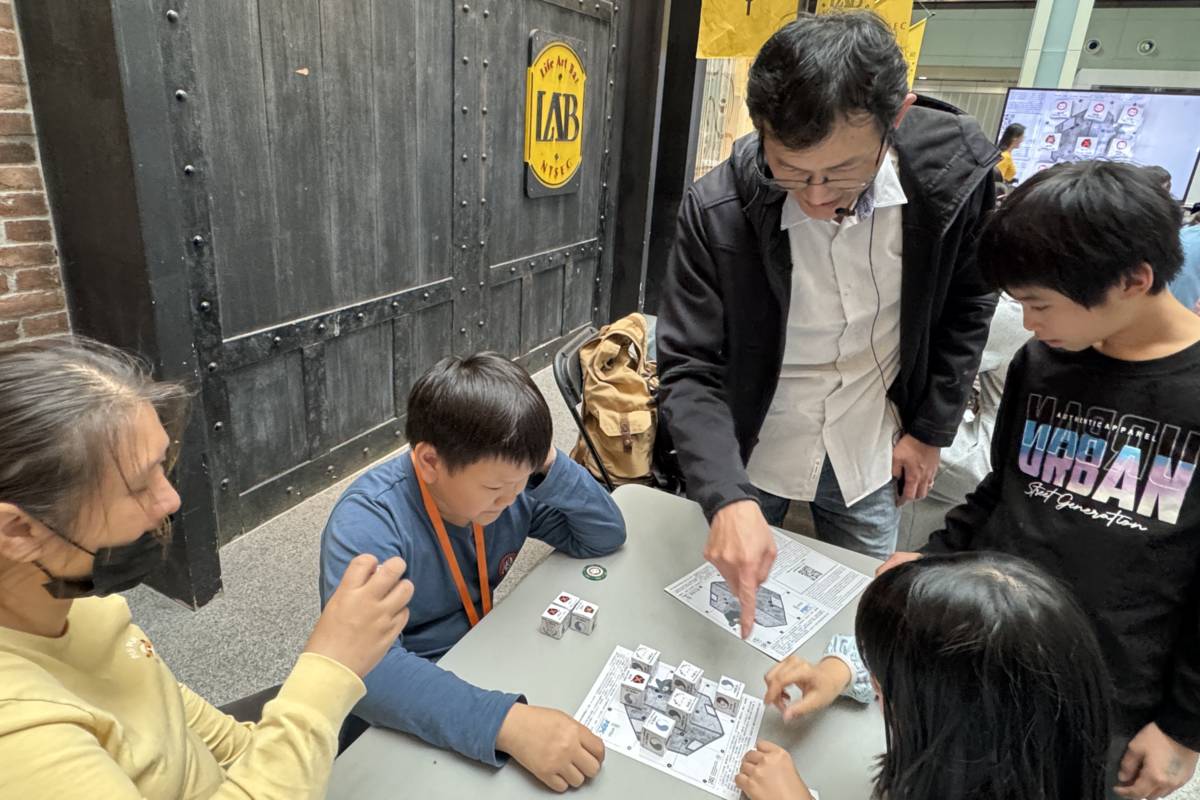 中原大學溫文鈺教授於兒童節教民眾玩量子井字棋。(科教館提供)