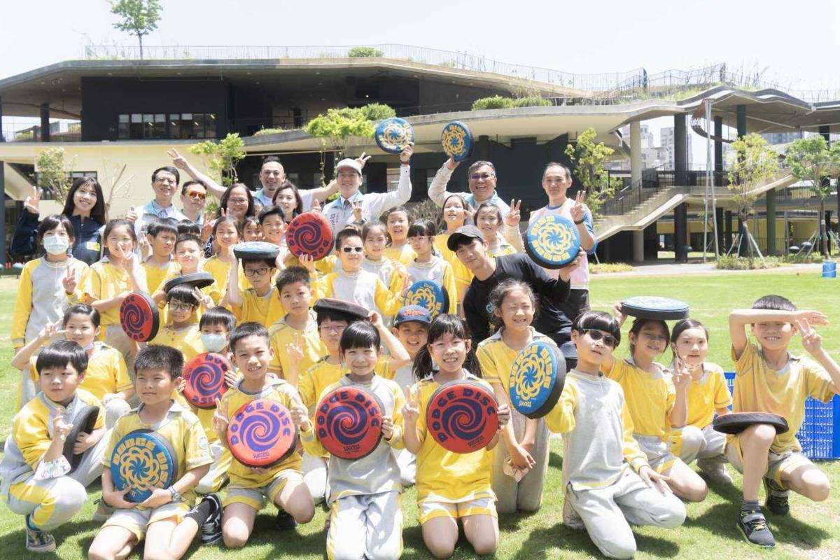 邱代理市長與關埔國小的孩子們一起在中央草原玩飛盤同樂。(新竹市政府提供)