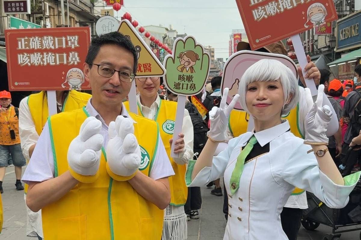 疾管署由副署長羅一鈞(左)擔任「防疫隊長」，率領疾管署《疾病擬人 Disease》人氣角色「白靜」，組成「防疫特攻隊」隨鑾轎抵達北港朝天宮 (疾管署提供)