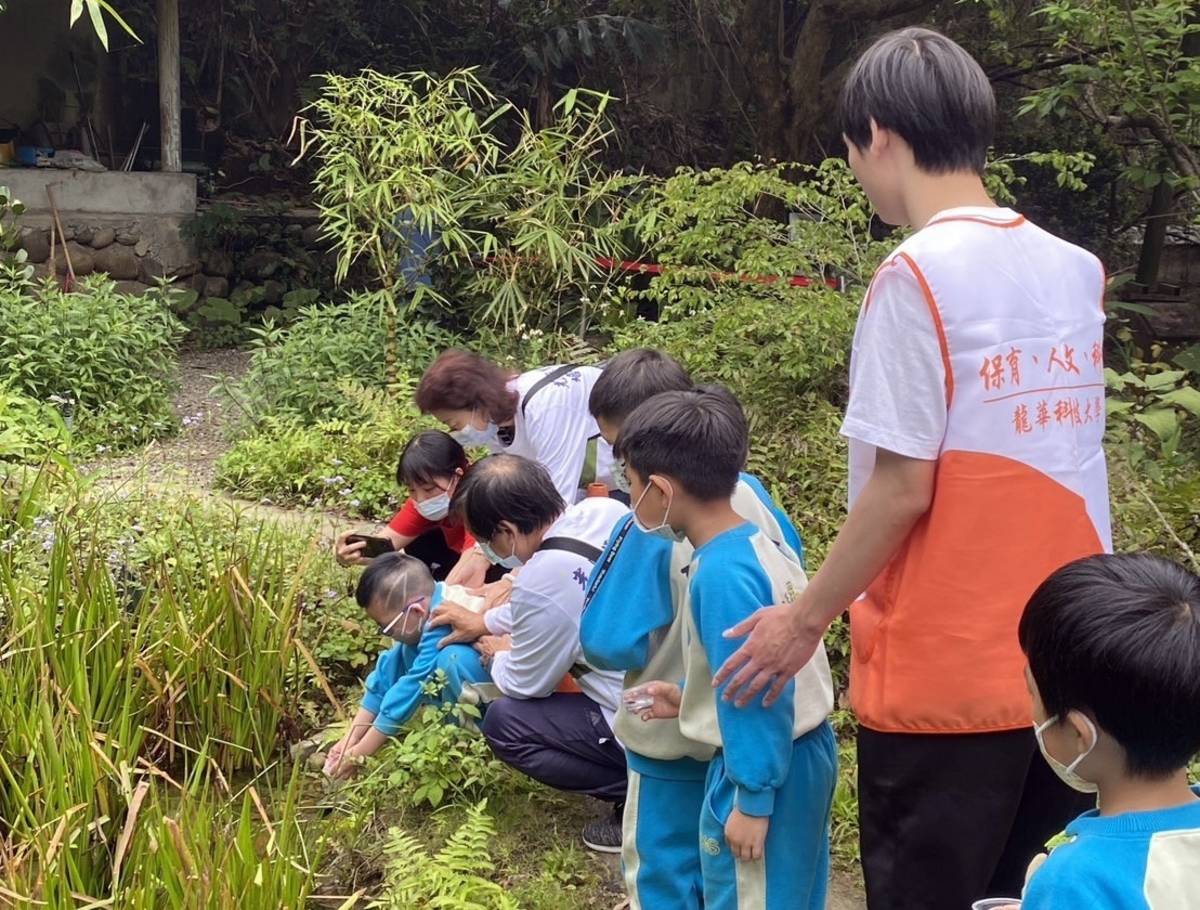 「龍華師生攜手光興里志工團隊，帶領育全幼兒園的小朋友野放螢火蟲。（龍華科大提供）