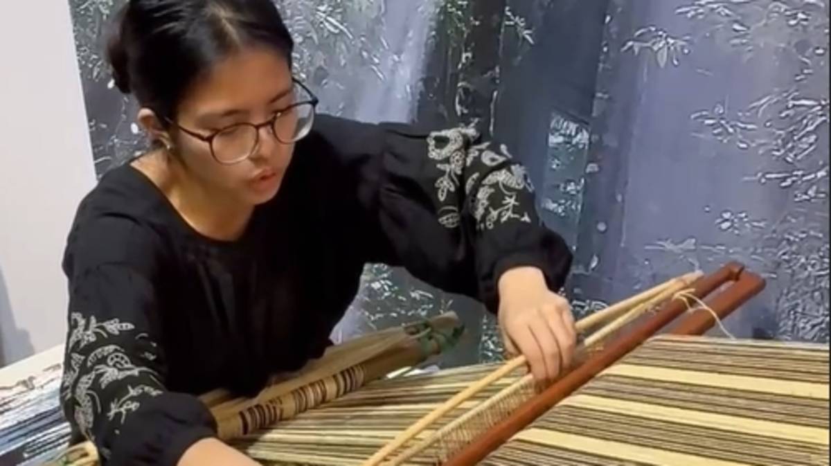 策展人羅娜.弗耐示範水平式腰帶地織機的織布方法