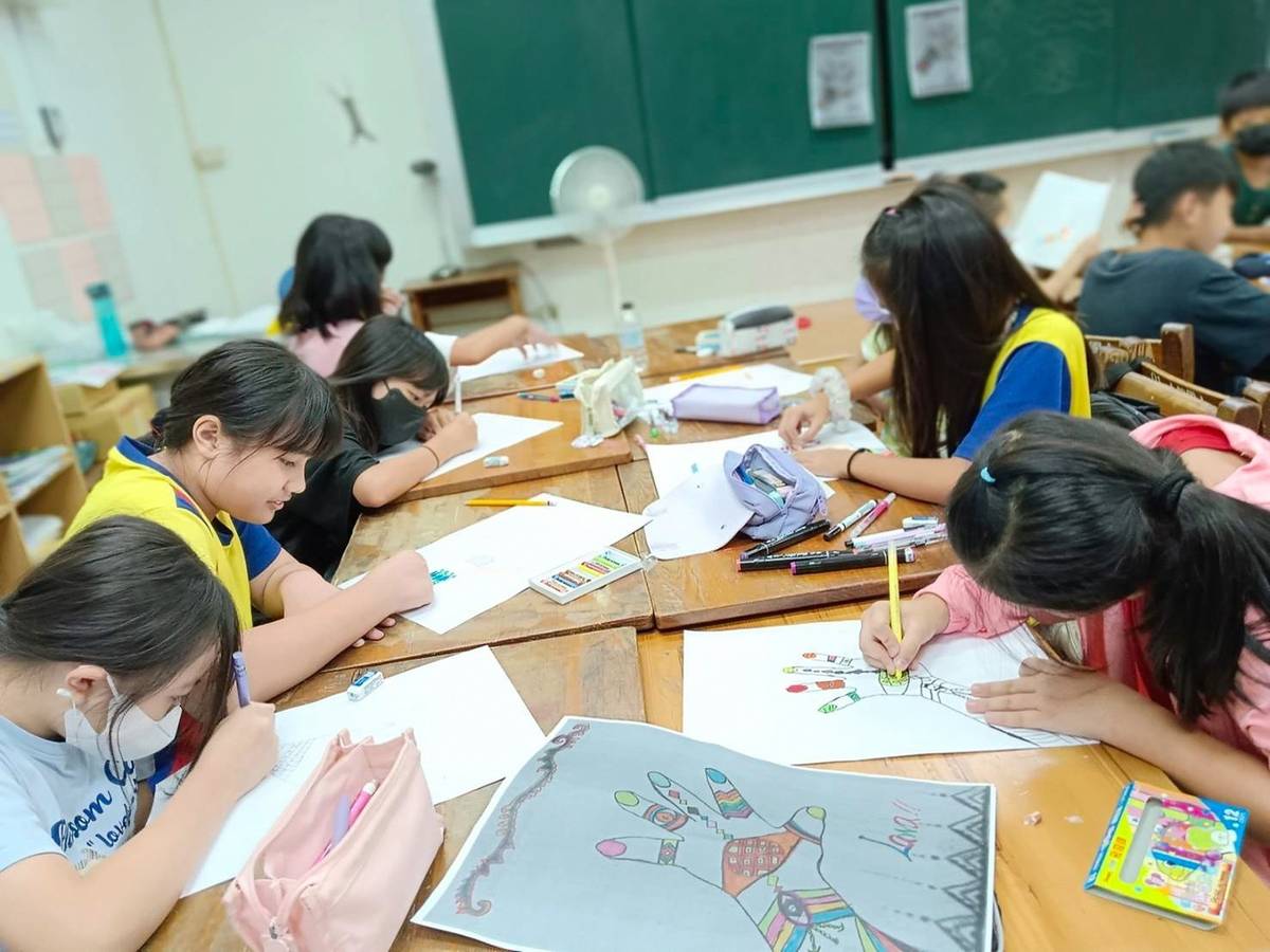 新竹縣上舘國小學生正在創作泰雅族圖騰，融入新意點綴身體外觀 (教育部提供)