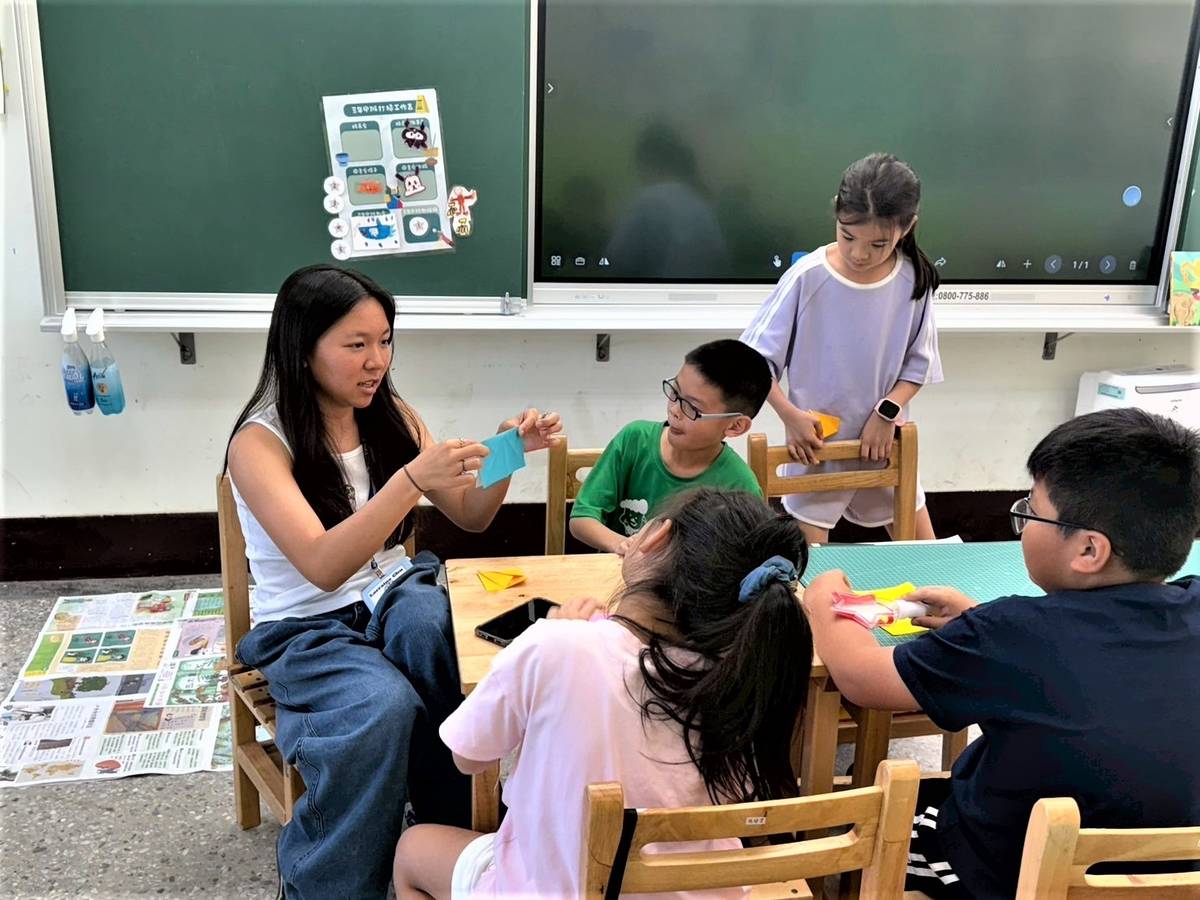 美國高中生Lorraine(左1)在美術課與小朋友一同上美術課程體驗摺紙