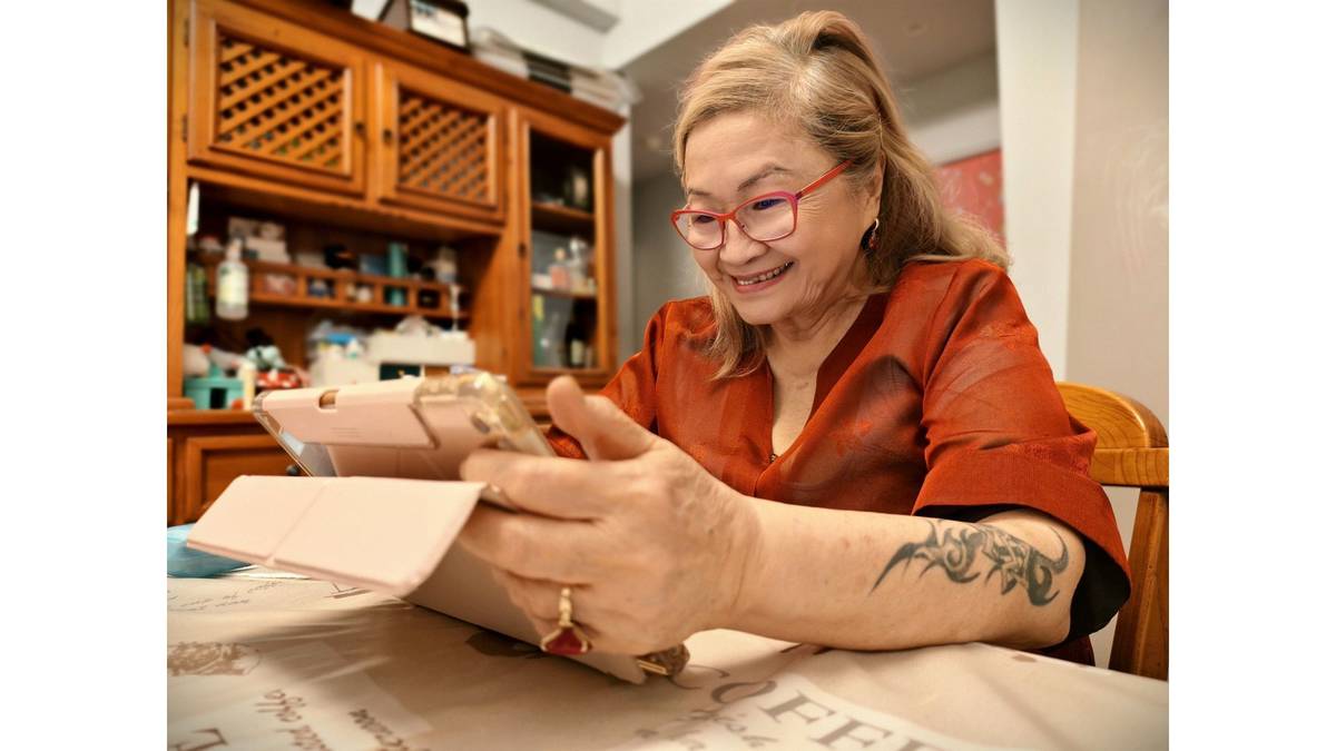 黃宜儀老師熟練操作平板，挑選旅遊照片