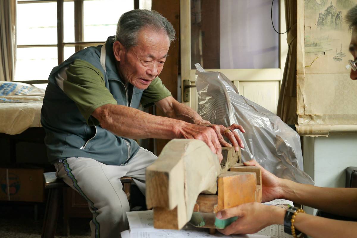 重要文化資產保存技術「大木作技術」保存者許漢珍於7月5日辭世，長期致力於傳統大木作技術，以及廟宇空間木作結網技術傳承，圖為其講解斗拱搭接方式。（成功大學建築系徐明福教授研究室提供）