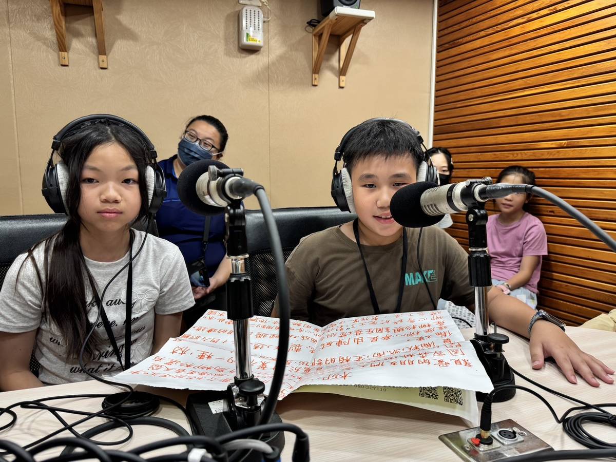 小小導覽員們寫下大字報，在麥克風前介紹知本森林遊樂區