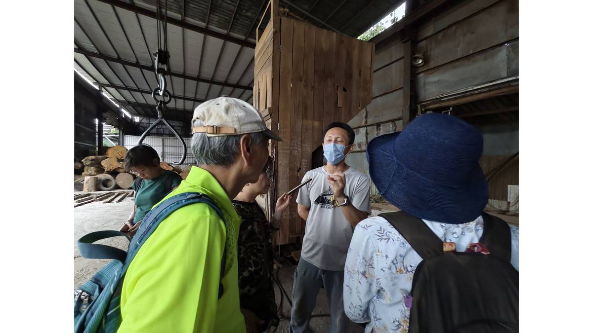 三義巨象製材所老闆，45歲的朱原賢(中)先生，正介紹製材所。