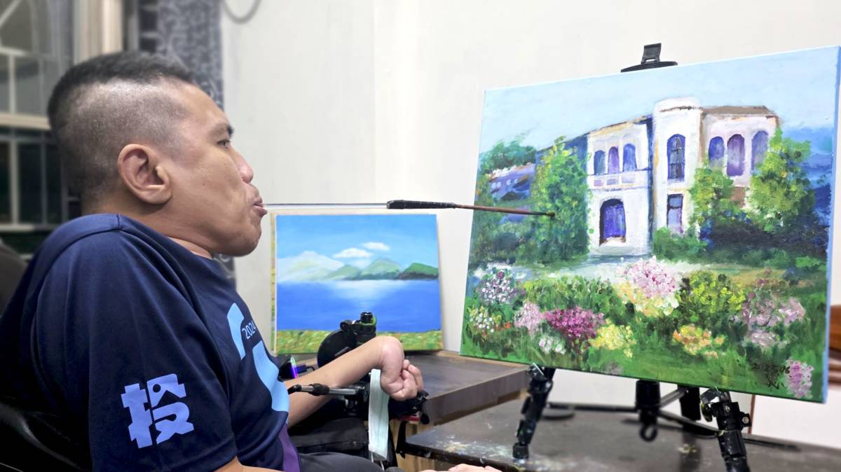 邱華忠不向命運低頭，以口作畫，他相信天無絕人之路。