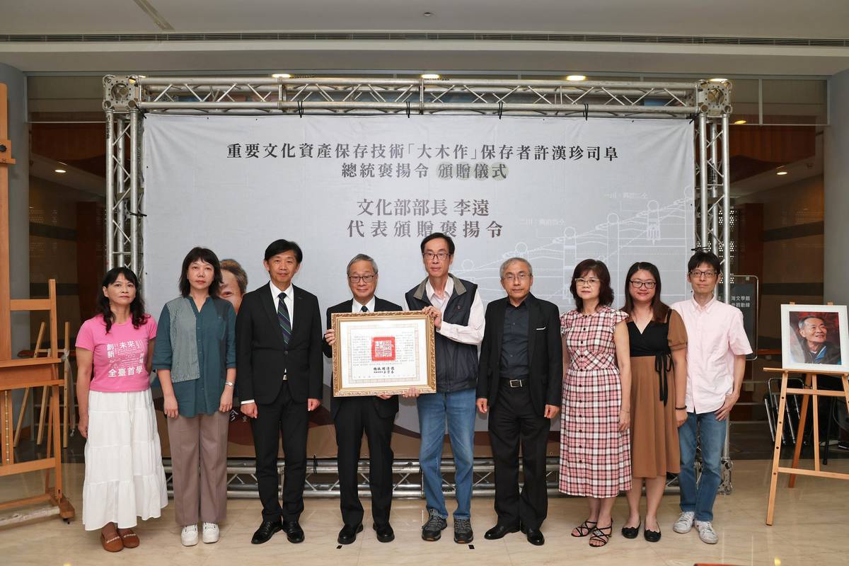 文化部長李遠（左4）代表頒贈總統褒揚令，由許漢珍兒子許弘杰（中）代表受贈。(文化部提供)