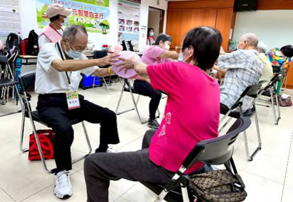 長者和家人以彈力球做雙人互動伸展與反應訓練
